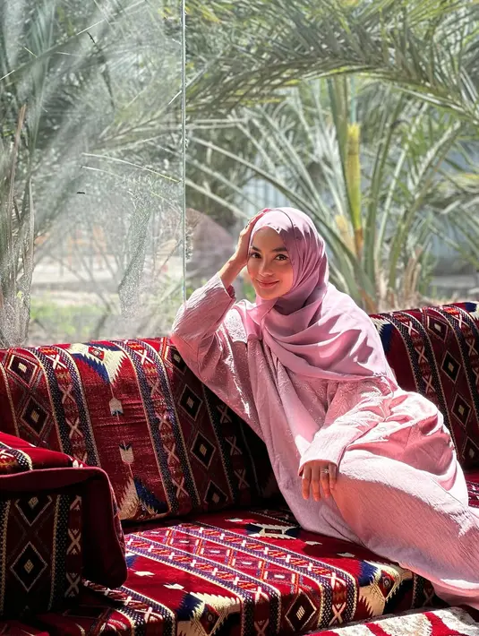 Duduk di sofa, Ririn Ekawati tampil menawan dengan kaftan pink berpayet yang dipadu dengan hijab [@ririnekawati]