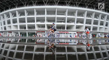 Warga bersepeda di kawasan lingkar luar Stadion Gelora Bung Karno (GBK), Jakarta, Minggu (21/1). Pascarenovasi, kawasan sekitar Stadion GBK kembali dipadati warga yang berolahraga. (Liputan6.com/Helmi Fithransyah)