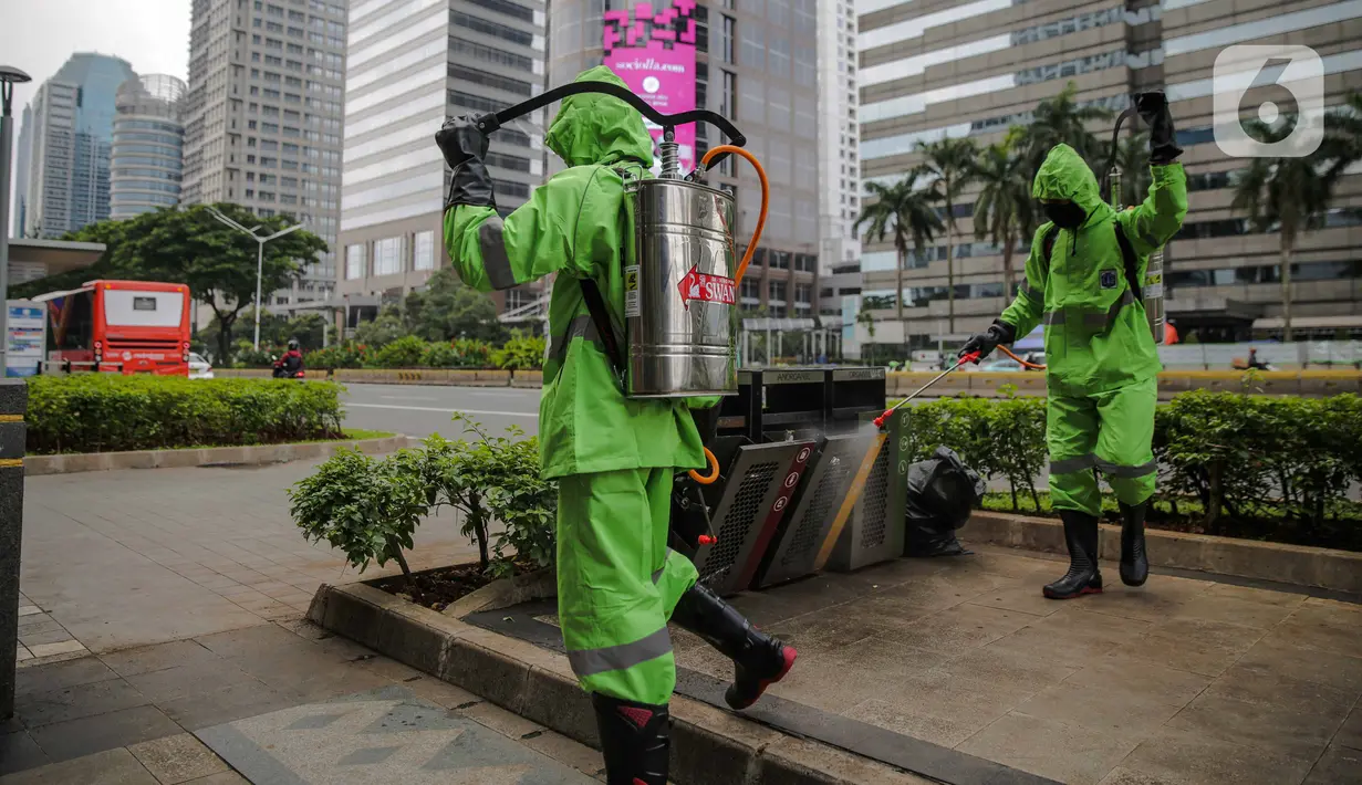 Petugas menyemprotkan cairan disinfektan di ruang publik kawasan pedestrian Sudirman, Jakarta, Kamis (19/3/2020). Penyemprotan dilakukan untuk antisipasi dan pencegahan penyebaran COVID-19 di lingkungan ruang publik yang banyak di gunakan oleh masyarakat. (Liputan6.com/Faizal Fanani)