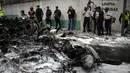 Petugas Polisi berjaga disamping bangkai pesawat yang hangus terbakar di Guatemala City, Guatemala, Sabtu (21/11/2015). Akibat kejadian ini dua awak pesawat dibawa kerumah sakit. (REUTERS/Jorge Dan Lopez)