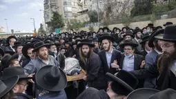Yahudi ultra-Ortodoks membawa jenazah rabbi terkemuka Meshulam Soloveitchik selama pemakamannya di Yerusalem, Minggu (31/1/2021). Rabi Meshulam Dovid Soloveitchik meninggal pada usia 99 tahun usai terpapar virus corona. (AP Photo/Ariel Schalit