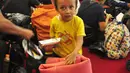 Seorang anak saat menunggu di Pelabuhan Tanjung Emas, Semarang , Senin (25/1). Total ada 42 orang eks Gafatar yang sakit, terinci 28 dewasa dan 14 anak-anak. mengalami menderita dehidrasi, demam, dan  muntah.  (Liputan6.com/Gholib)