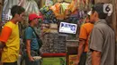 Sejumlah pedagang pasar nonton bareng debat perdana calon presiden Pemilihan Presiden (Pilpres) 2024 yang diselenggarakan oleh Komisi Pemilihan Umum (KPU) di Pasar Kebayoran Lama, Jakarta, Selasa (12/12/2023). (Liputan6.com/Angga Yuniar)