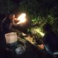 Warga di Desa Pojok Watu, Kecamatan Sambong, Kabupaten Blora, Jawa Tengah, Selasa malam (15/3/2022), mengumpulkan minyak milik Pertamina yang bocor. (Liputan6.com/ Ahmad Adirin)