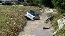 Mobil masuk ke sebuah kanal akibat banjir bandang di Ibu Kota Skopje, Makedonia, Minggu (7/8). Pemerintah menyatakan keadaan darurat sehari setelah setidaknya 21 orang tewas dalam banjir bandang yang disebabkan badai. (Robert ATANASOVSKI/AFP)