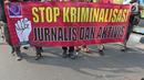 Sejumlah Jurnalis yang tergabung dalam Aliansi Jurnalis Independen (AJI) membentangkan spanduk dan poster saat menggelar aksi menuntut pencabutan status tersangka Dandhy Dwi Laksono pada Car Free Day di Kawasan Bundaran HI, Jakarta, Minggu (29/9/2019).