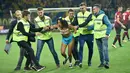 Petugas membawa wanita yang melakukan aksi protes di stadion di Kharkiv (2/9). Wanita itu memprotes rezim Erdogan yang dinilai telah membunuh kebebasan. (AFP Photo/Sergei Supinsky)