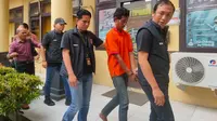 Suganda digiring ke tahanan di Polrestabes Palembang setelah melakukan pembunuhan sadis yang menewaskan dua orang korban (Liputan6.com / Nefri Inge)