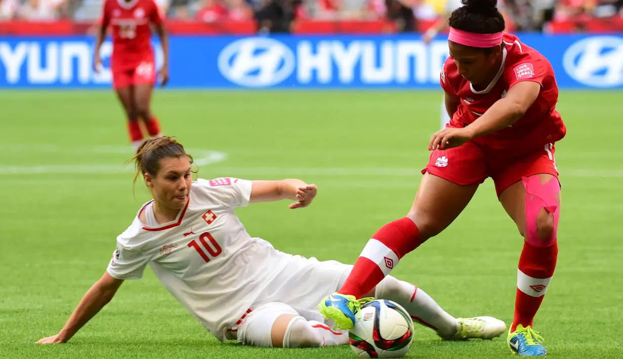 Gelandang Kanada, Desiree Scott mengontrol bola dari kejaran pemain Swiss Ramona Bachmann saat Piala Dunia wanita 2015 di BC Place Stadium, Senin (22/6/2015). Kanada menang 1-0 atas Swiss lewat gol Josee Belanger. (Reuters/Anne Marie Sorvin)