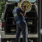 Seorang pekerja mengangkat velg yang telah diperbaharui di sebuah bengkel di Ampang, di pinggiran kota Kuala Lumpur, Malaysia (18/7). (AFP Photo/Mohd Rasfan)