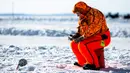 Seorang pemancing es memancing dalam acara Brainerd Jaycees Ice Fishing Extravaganza tahunan ke-32 di Gull Lake's Hole di Teluk Day, Minnesota pada 29 Januari 2022. Hampir 10.000 pemancing dari Minnesota dan negara bagian lain menghadiri kontes memancing es amal terbesar di dunia. (Kerem Yucel/AFP)