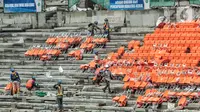 Pekerja saat menyelesaikan pemasangan bangku penonton di lapangan utama Jakarta International Stadium (JIS), Papanggo, Jakarta Utara, Selasa (7/12/2021). Progres pembangunan stadion sepakbola dengan kapasitas 82.000 penonton tersebut saat ini baru mencapai 87 persen. (merdeka.com/Iqbal S Nugroho)