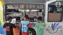 Anak-anak membaca buku di Perpustakaan Keliling kawasan Jatinegara, Jakarta, Rabu (29/9/2021). Mobil Perpustakaan Keliling yang difasilitasi Dinas Perpustakaan dan Kearsipan DKI itu merupakan sarana dan upaya pemerintah dalam meningkatkan minat baca anak sejak dini. (merdeka.com/Iqbal S Nugroho)
