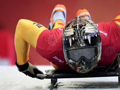 Atlet balap kereta salju, Akwasi Frimpong dari Ghana memulai sesi latihan pada Olimpiade Musim Dingin Pyeongchang 2018 di Olympic Sliding Center di Pyeongchang, Korsel (21/2). Akwasi memakai helm dengan design kepala harimau. (AFP Photo/Mark Ralston)