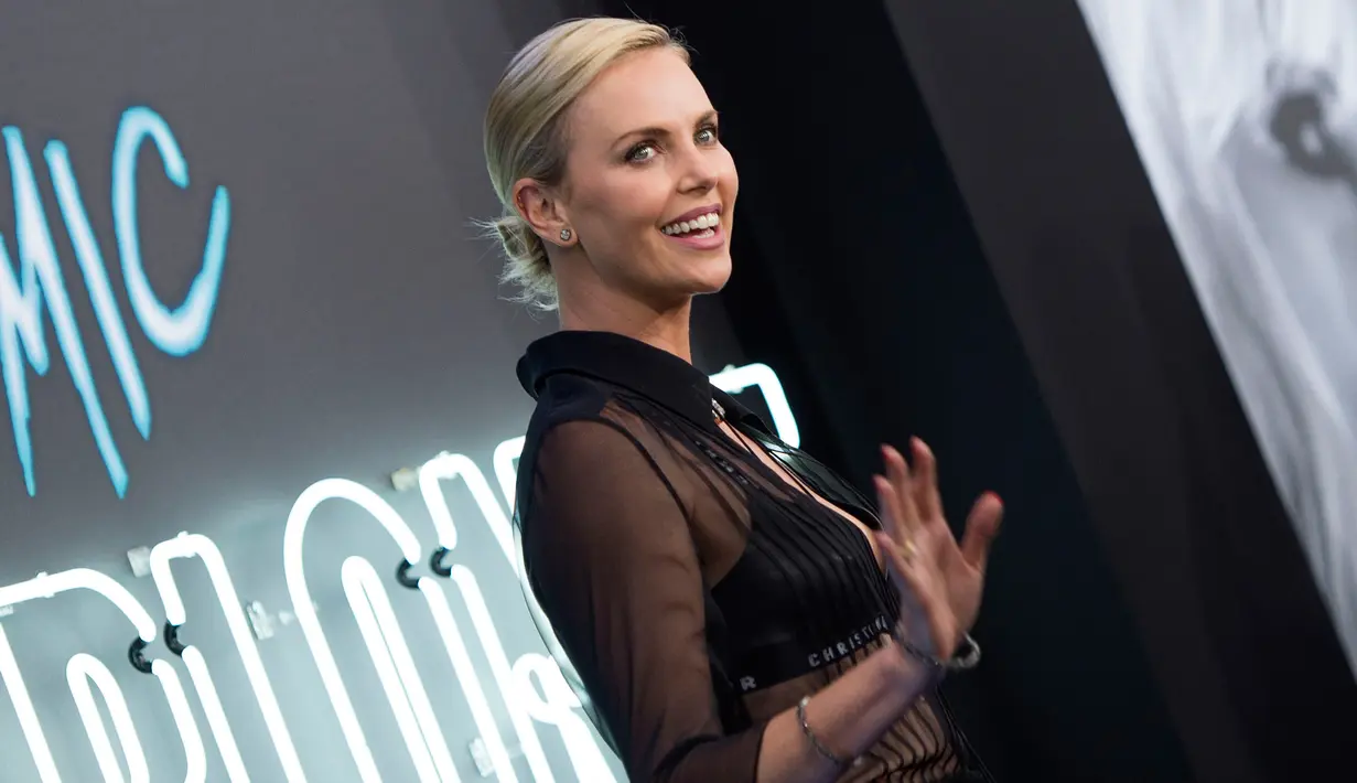 Charlize Theron menyapa awak media saat menghadiri pemutaran film terbarunya "Atomic Blonde" Fitur Fokus di Los Angeles, California (24/7). Aktris 41 tahun ini tampil dengan rok mini dan sepatu bot hitam. (AFP Photo/Valerie Macon)