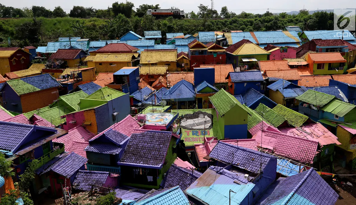 Suasana atap rumah kampung warna-warni dari atas jembatan di Kelurahan Kesatrian, Kota Malang, Minggu (5/11). Ratusan rumah yang di cat gambar tersebut untuk menarik wisatawan. (Liputan6.com/Fery Pradolo)