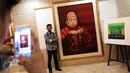 Pengunjung berfoto di dekat lukisan Presiden RI ke-4 Abdurrahman Wahid (Gusdur) saat pameran di Gedung PBNU, Jakarta, Senin (30/1). Pameran tersebut digelar dalam rangka Harlah NU ke-91. (Liputan6.com/Johan Tallo)