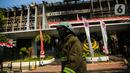 Petugas pemadam kebakaran melintas di depan gedung utama Kejaksaan Agung yang terbakar di Jakarta, Minggu (23/8/2020). Pemadaman kebakaran di gedung Kejaksaan Agung kini sudah memasuki tahap pendinginan, pascapemadaman dilakukan hingga lebih dari 12 jam. (Liputan6.com/Faizal Fanani)