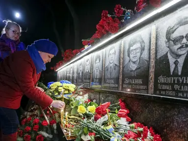 Seorang wanita meletakkan bunga di monumen peringatan 30 tahun bencana nuklir Chernobyl, di kota Slavutych, Ukraina, Selasa (26/4). Ledakan di Chernobyl pada 26 April 1986 silam merupakan kecelakaan terburuk dalam sejarah nuklir. (REUTERS/Gleb Garanich)