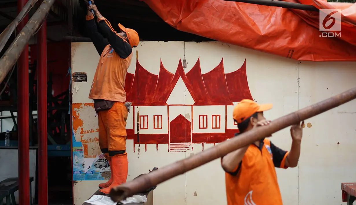 Petugas PPSU membongkar bangunan kios pedagang nasi kapau di Jalan Kramat Raya, Senen, Jakarta, Jumat (6/9/2019). Pembongkaran disebabkan adanya rencana revitalisasi trotoar di jalan tersebut. (Liputan6.com/Immanuel Antonius)