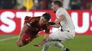 Pemain AS Roma, Paulo Dybala, terjatuh saat berusaha melewati pemain AC Milan, Ismael Bennacer, pada leg kedua perempat final Liga Europa di Stadion Olimpico, Roma, Jumat (19/4/2024). (AP Photo/Andrew Medichini)