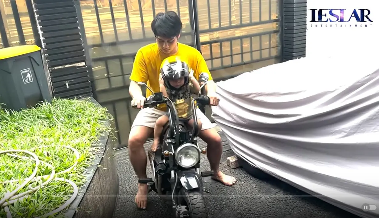 Tampak Abang L mengenakan helm kebesaran. Bahkan, hingga menutup hingga mukanya. [Youtube/Leslar Entertainment]