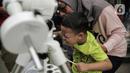 Pengunjung mengamati gerhana matahari cincin menggunakan teleskop di Planetarium Taman Ismail Marzuki, Jakarta, Kamis (26/12/2019). Planetarium menyediakan sekitar 10 teleskop dan kacamata khusus agar pengunjung bisa menyaksikan gerhana matahari cincin dengan aman. (Liputan6.com/Faizal Fanani)