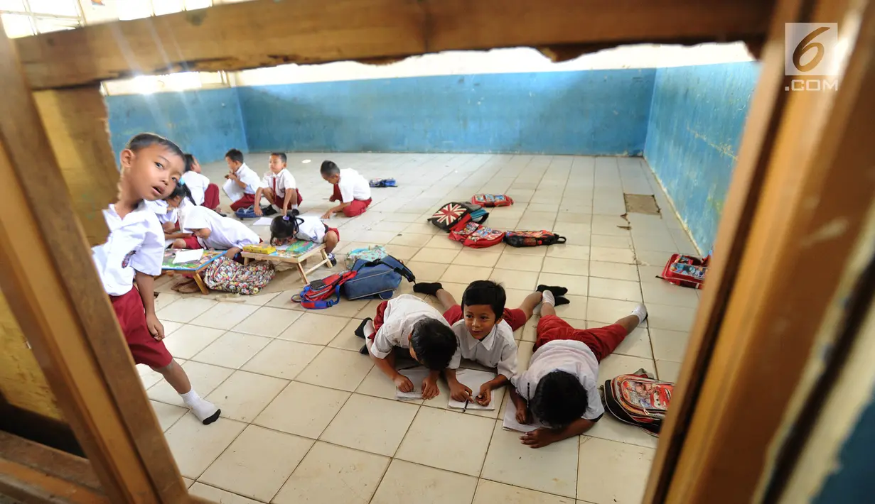 Sejumlah murid kelas II melakukan kegiatan belajar di lantai kelas SDN Kertajaya 2, Rumpin, Bogor, Senin (3/9). Tidak tersedianya meja dan kursi di tiga ruang kelas menyebabkan mereka belajar di lantai selama lebih dari 3 tahun. (Merdeka.com/Arie Basuki)