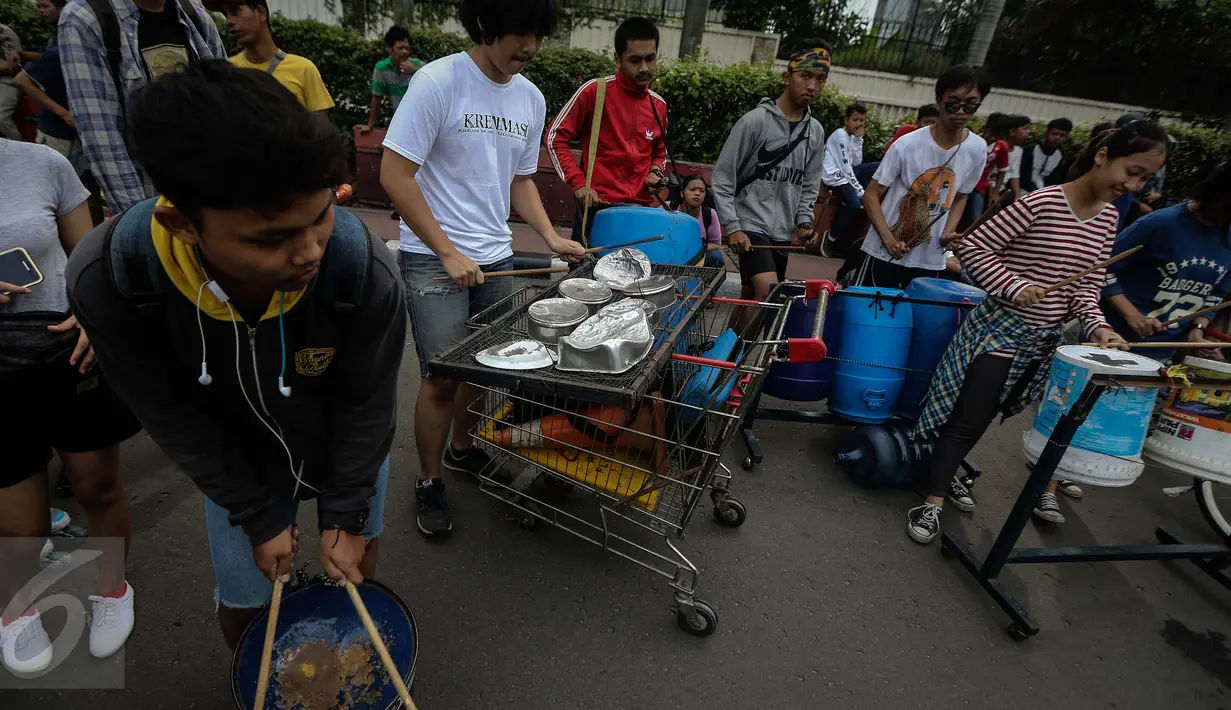 Sejumlah mahasiswa dari Universitas ISIP bermain alat musik dari barang bekas di Car Free Day kawasan Bundaran HI, Jakarta, Minggu (15/1). (Liputan6.com/Faizal Fanani)