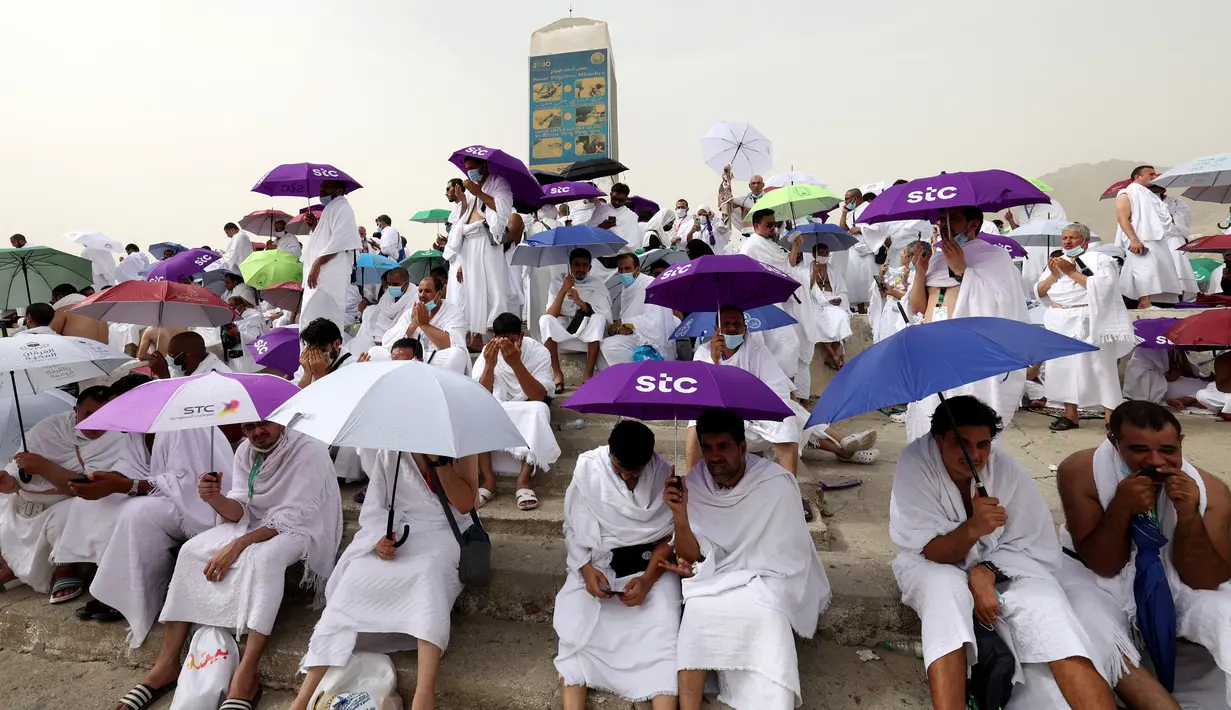Jemaah haji berkumpul di sekitar Jabal al-Rahma (Gunung Rahmat) saat menunaikan prosesi wukuf di Padang Arafah, tenggara Kota Suci Mekah, Arab Saudi, Senin (19/7/2021). Wukuf di Padang Arafah dua tahun terakhir berada dalam pembatasan karena pandemi corona virus COVID-19. (FAYEZ NURELDINE/AFP)