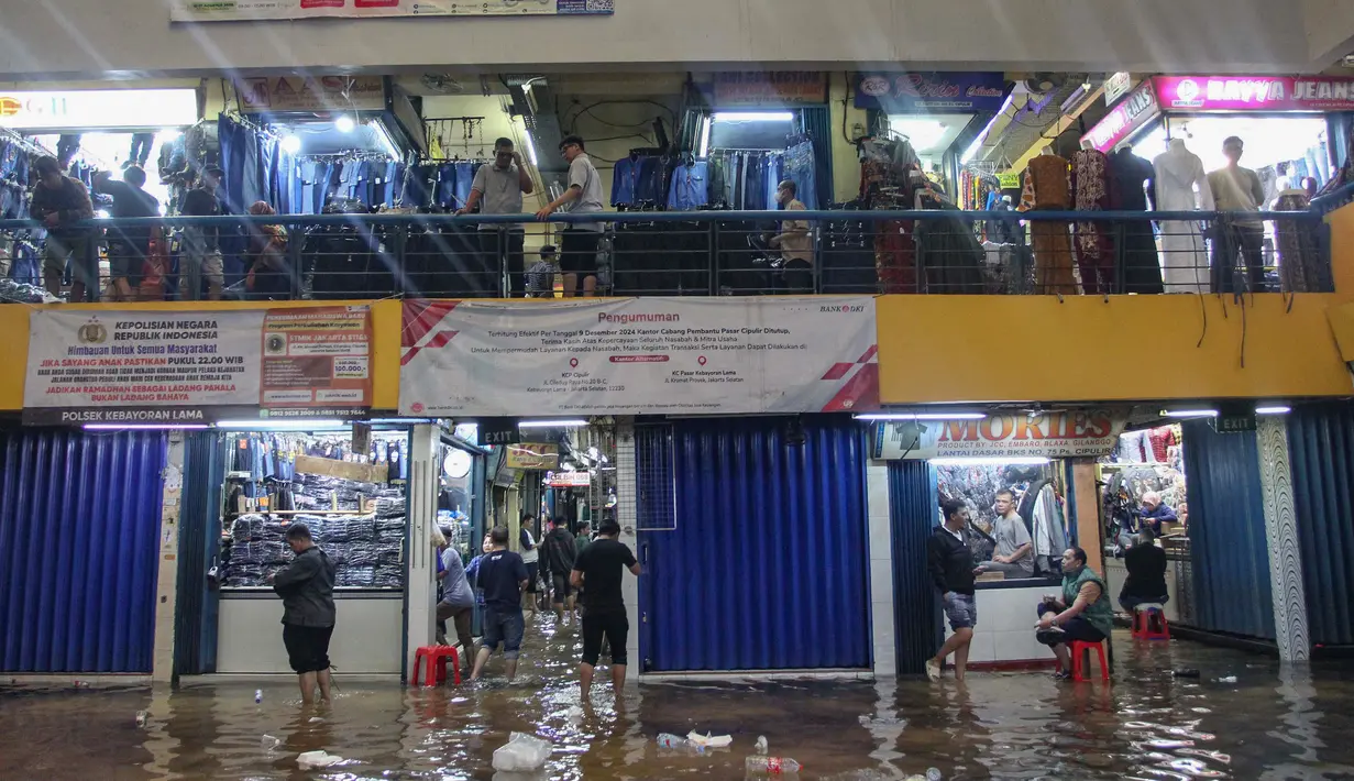 Aktivitas pedagang dan pembeli di Pasar Cipulir, Jakarta, Jumat (23/1/2026). Genangan banjir setinggi sekitar 20 sentimeter menggenangi area dalam Pasar Cipulir, Jakarta. (merdeka.com/Arie Basuki)