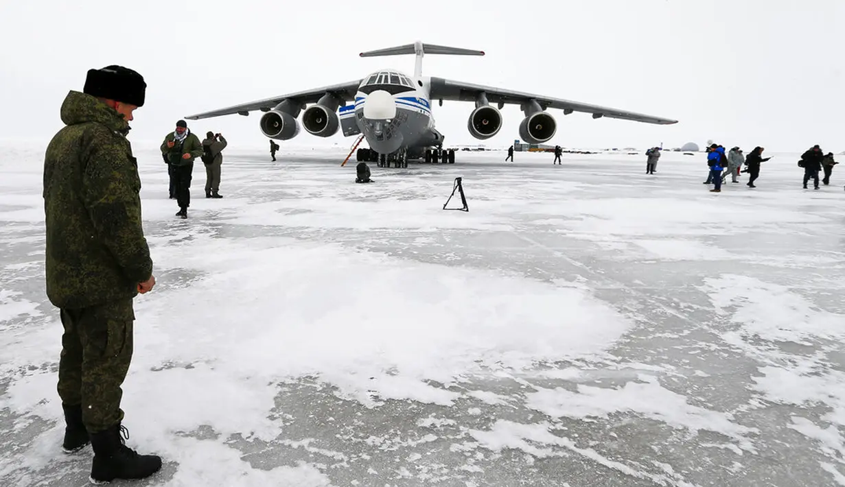 Seorang perwira Rusia berdiri dekat pesawat kargo militer Il-76 yang mendarat di Pulau Alexandra Land dekat Nagurskoye, Rusia, Senin (17/5/2021). Pangkalan militer ini dipenuhi rudal, radar serta landasan pacu yang dapat menangani semua jenis pesawat. (AP Photo/Alexander Zemlianichenko)