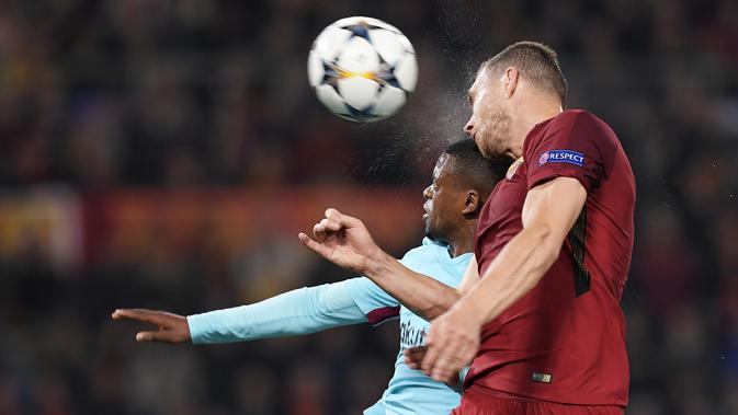 Bek Barcelona, Nelson Semedo melompat untuk merebut bola dari pemain depan AS Roma, Edin Dzeko, pada laga leg kedua perempat final Liga Champions di Stadion Olimpico, Selasa (10/4). Barcelona secara mengejutkan dikalahkan AS Roma 0-3. (LLUIS GENE/AFP)