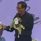 Momen lucu saat Mahfud MD tukeran kado dengan Gibran Rakabuming di acara Ulang Tahun Mata Najwa ke-13. (Dok: YouTube Mata Najwa)
