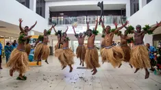 Penari tradisional dengan rok rumput menyambut wisatawan di Nadi, Fiji, Rabu (1/12/2021). Fiji membuka perbatasannya untuk pelancong internasional pertama kalinya sejak pandemi Covid-19 melanda dunia dan menghancurkan ekonominya yang bergantung pada pariwisata. (Leon LORD/AFP)