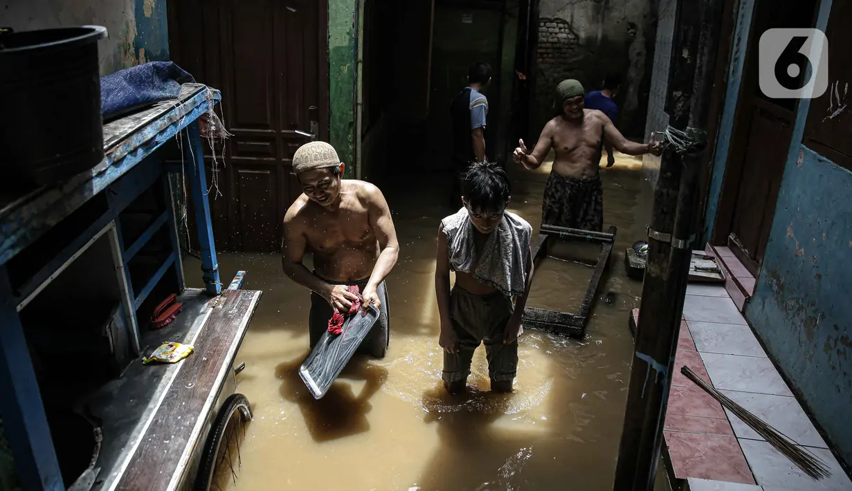 Warga bersih-bersih perabotan usai terendam banjir di kawasan Kampung Melayu, Jakarta, Senin (8/11/2021). Warga belum mengungsi dan masih berharap air akan surut. (Liputan6.com/Faizal Fanani)