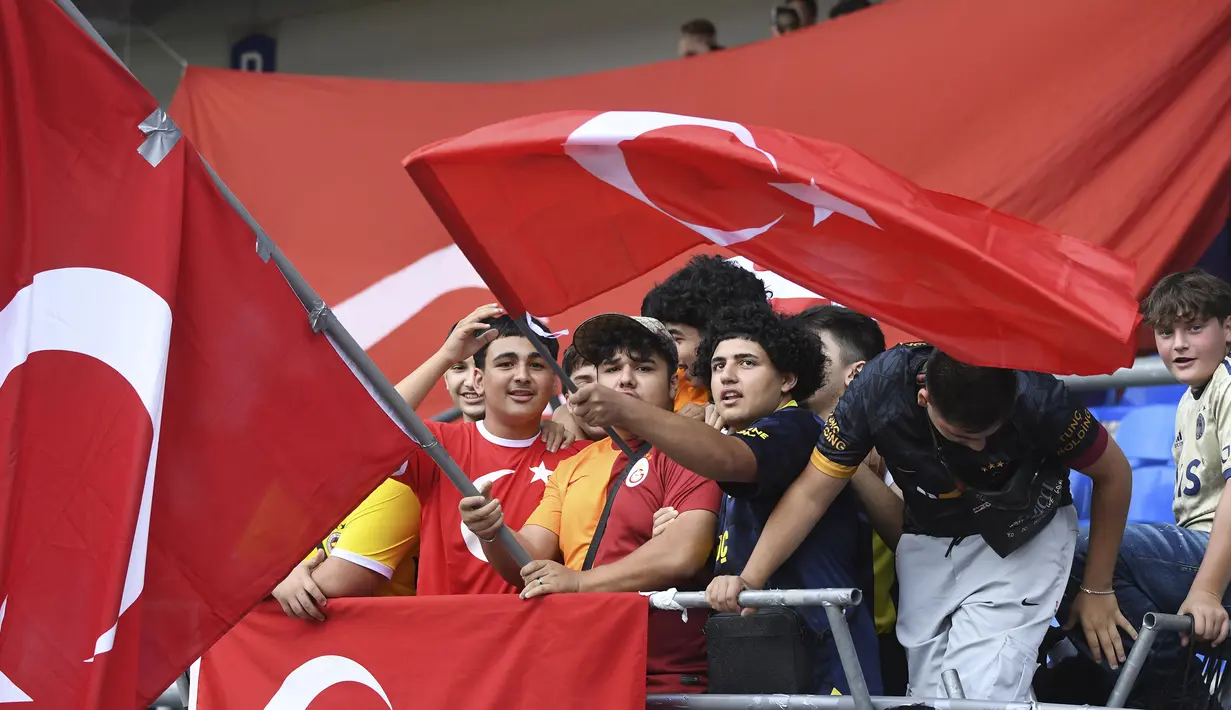 Para suporter Timnas Turki mengibarkan bendera sebelum dimulainya laga persahabatan FIFA Matchday menghadapi Timnas Jepang di Luminus Arena, Genk, Belgia, Selasa (12/9/2023) malam WIB. (AP Photo/Frederic Sierakowski)