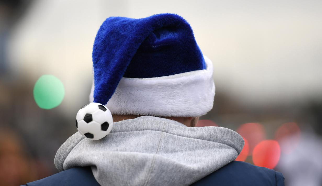  Seorang Fan dengan topi Sinterklas berwarna biru dan bola kecil bersiap menyaksikan laga Premier League antara  West Bromwich Albion v Watford, (3/12/2016).  (Reuters/Anthony Devlin)