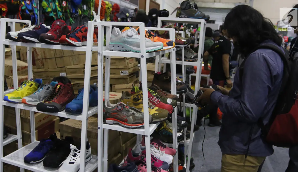 Pengunjung melihat sepatu dalam Pameran Indonesia Outdoor Festival (Indofest) 2018 di JCC Senayan, Jakarta, Jumat (4/5). Pameran Indofest berlangsung 3-6 Mei 2018. (Liputan6.com/Arya Manggala)