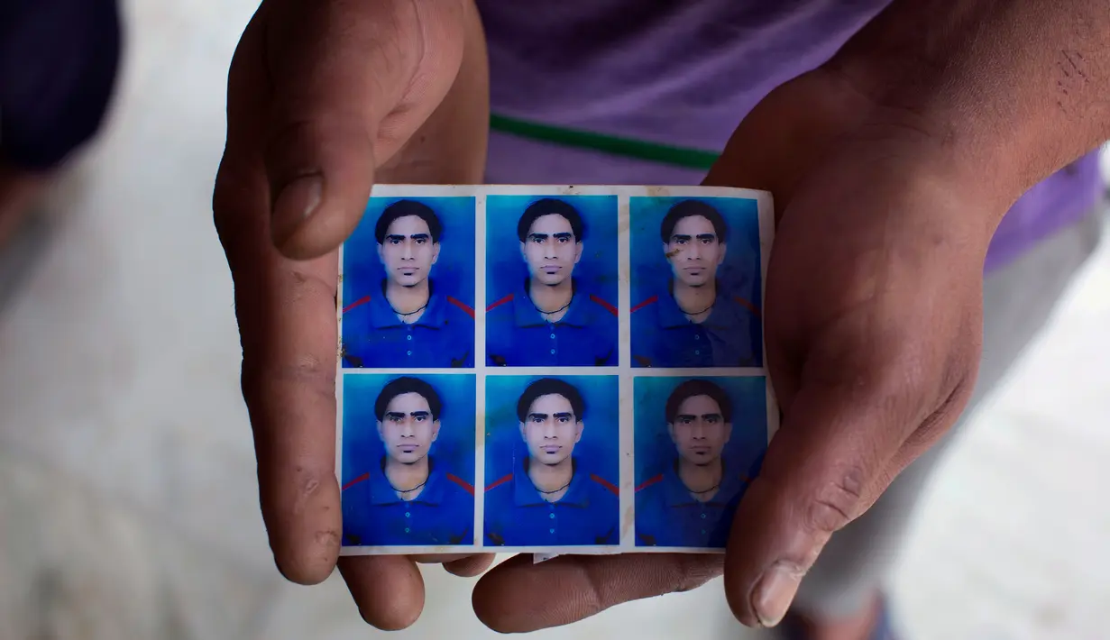 Vijay Kumar menampilkan foto adik laki-lakinya Indrajit Kumar yang jasadnya ditemukan terkubur di barat laut Mosul, India (21/3). Sebanyak 39 warga India yang diculik oleh Kelompok ISIS pada 2014 dikonfirmasi telah tewas. (AP/Ashwini Bhatia)