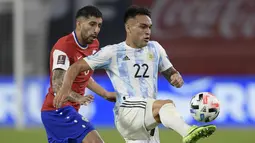 Penyerang Argentina, Lautaro Martinez mengontrol bola dari kawalan pemain Chile, Guiilermo Maripan dalam laga Kualifikasi Piala Dunia 2022 zona CONMEBOL, di Santiago del Estero, Argentina, Jumat (4/6/2021). Hasil ini membuat Argentina tetap di posisi kedua dengan 11 poin. (Juan Mabromata, Pool via A