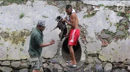 Petugas Animal Rescue menyelamatkan seekor anjing yang terjebak di gorong-gorong kali Gresik, Menteng, Jakarta Pusat, Rabu (23/5). Anjing ini terjebak selama 3 hari dan dibawa ke tempat penampungan. (Liputan6.com/Arya Manggala)