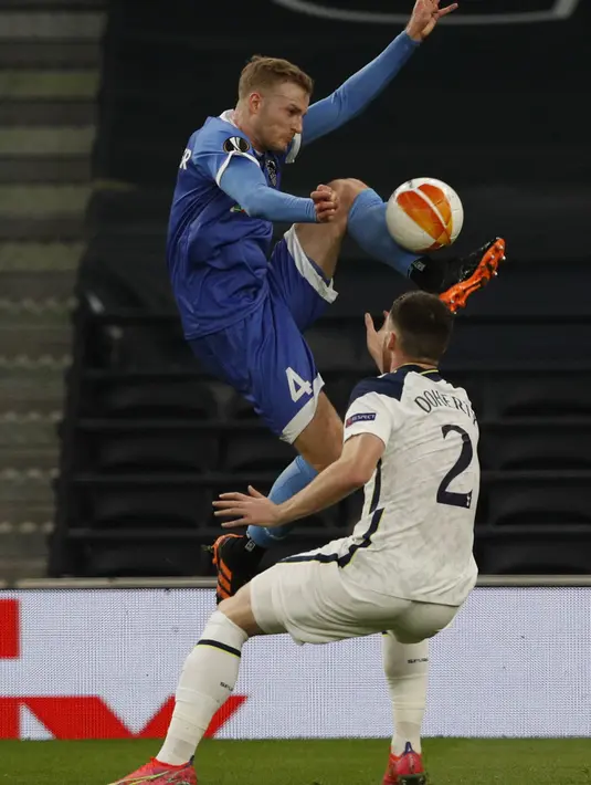 Bek Wolfsberg, Jonathan Scherzer (Kiri) berebut bola dengan bek Tottenham Hotspur, Matt Doherty pada leg kedua 32 besar Liga Europa di Tottenham Stadium, Kamis (25/2/2021). Tottenham Hotspur berpesta gol usai menang 4-0 atas Wolfsberger. (Adrian DENNIS / AFP)