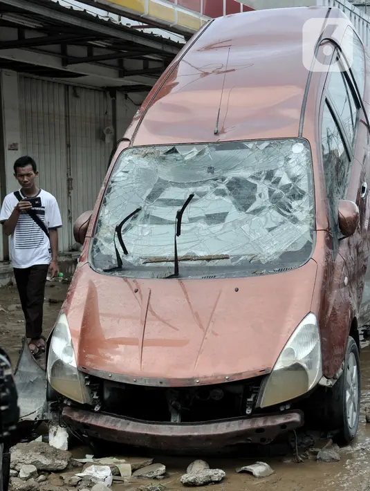 Kondisi mobil yang rusak akibat terjangan banjir di Perumahan Pondok Gede Permai, Jatiasih, Kota Bekasi, Jawa Barat, Kamis (2/1/2020). Derasnya terjangan banjir menyebabkan puluhan mobil terbalik dan belasan sepeda motor ringsek akibat terbawa arus. (merdeka.com/Iqbal Nugroho)