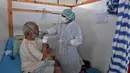 Seorang petugas medis Tunisia merawat pasien di gym yang diubah untuk menangani lonjakan infeksi COVID-19 di pusat kota Kairouan pada 4 Juli 2021. Tunisia tengah berjuang menghadapi tsunami COVID-19 sementara jumlah orang yang meninggal akibat virus corona terus melonjak tinggi. (FETHI BELAID/AFP)