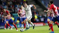 Gelandang Real Madrid, Gareth Bale menggiring bola dari kejaran pemain Atletico Madrid pada final Piala Super Eropa di Lillekula Stadium di Tallinn, Estonia, (15/8). Real Madrid kalah 4-2 atas Atletico. (AP Photo/Pavel Golovkin)