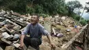 Salah satu korban menangis di atas puing-puing rumahnya yang rusak akibat gempa di Longtoushan, provinsi Yunan, Tiongkok, (6/8/2014). (REUTERS/Stringer)