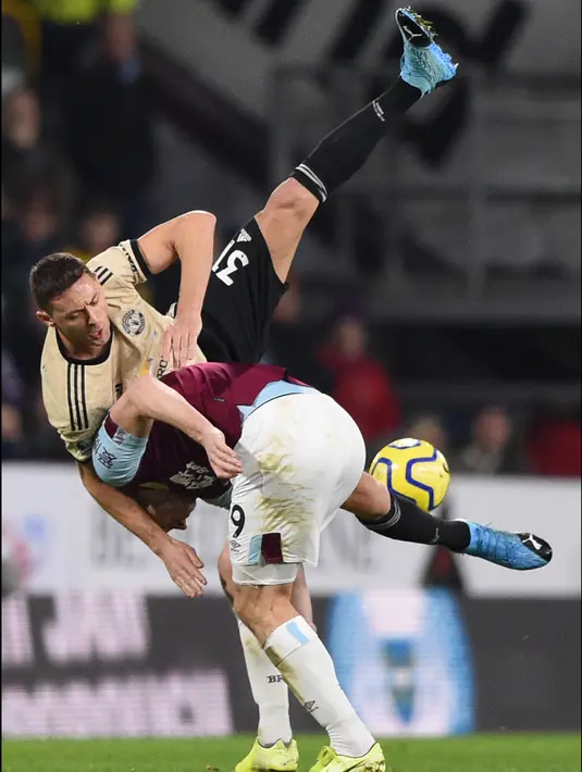 Pemain Manchester United Nemanja Matic (atas) dan pemain Burnley Chris Wood saat pertandingan Liga Inggris di Turf Moor, Burnley, Inggris, Sabtu (28/12/2019). MU menang 2-0 dan melonjak ke posisi lima klasemen. (Oli SCARFF/AFP)