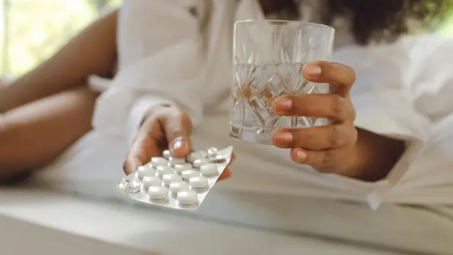 Wanita sedang minum obat