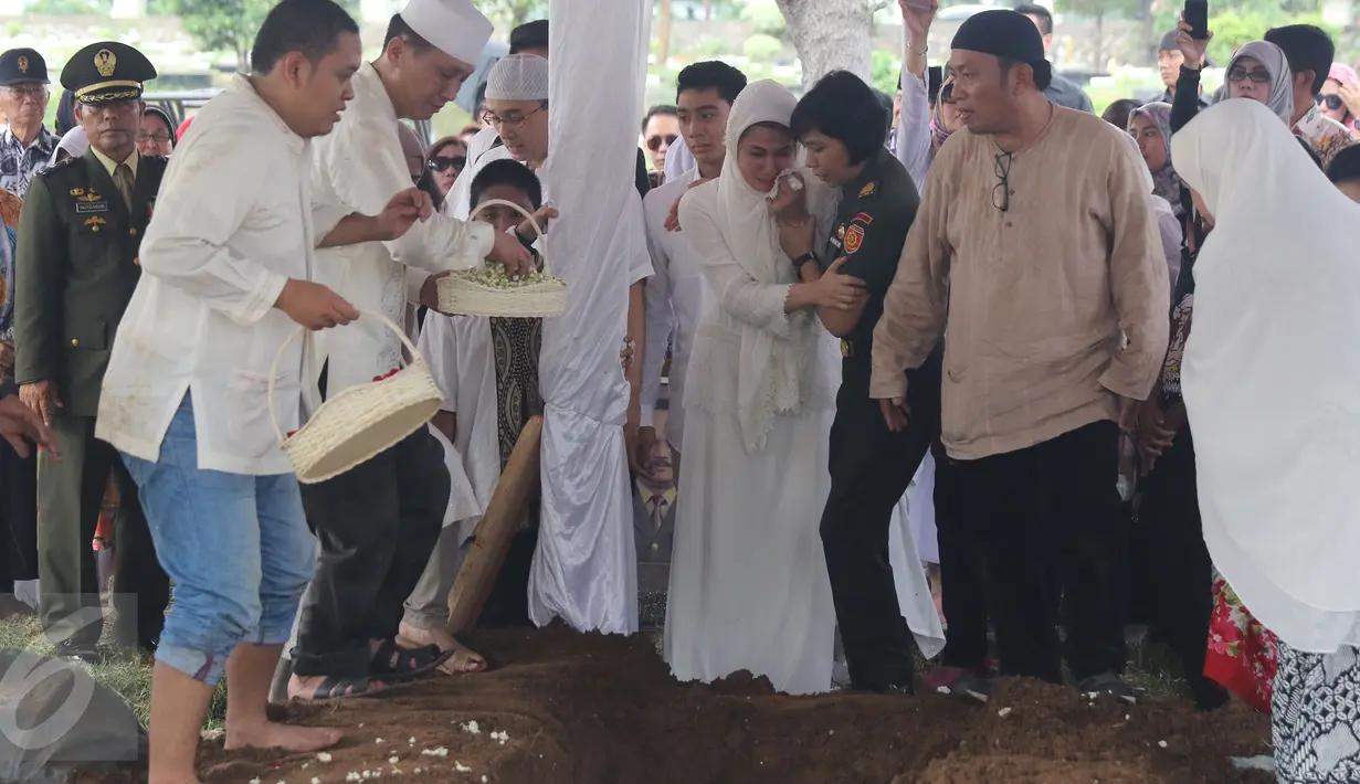 Marini Zumarnis tampak tak kuasa menahan kesedihan saat melihat jenazah ayahnya, Zumarnis Zein, di liang lahat TPU Karet Bivak, Jakarta, Jumat (17/6). Ayah Marini Zumarnis wafat pada usia 75 tahun karena komplikasi penyakit. (Liputan6.com/Herman Zakharia)